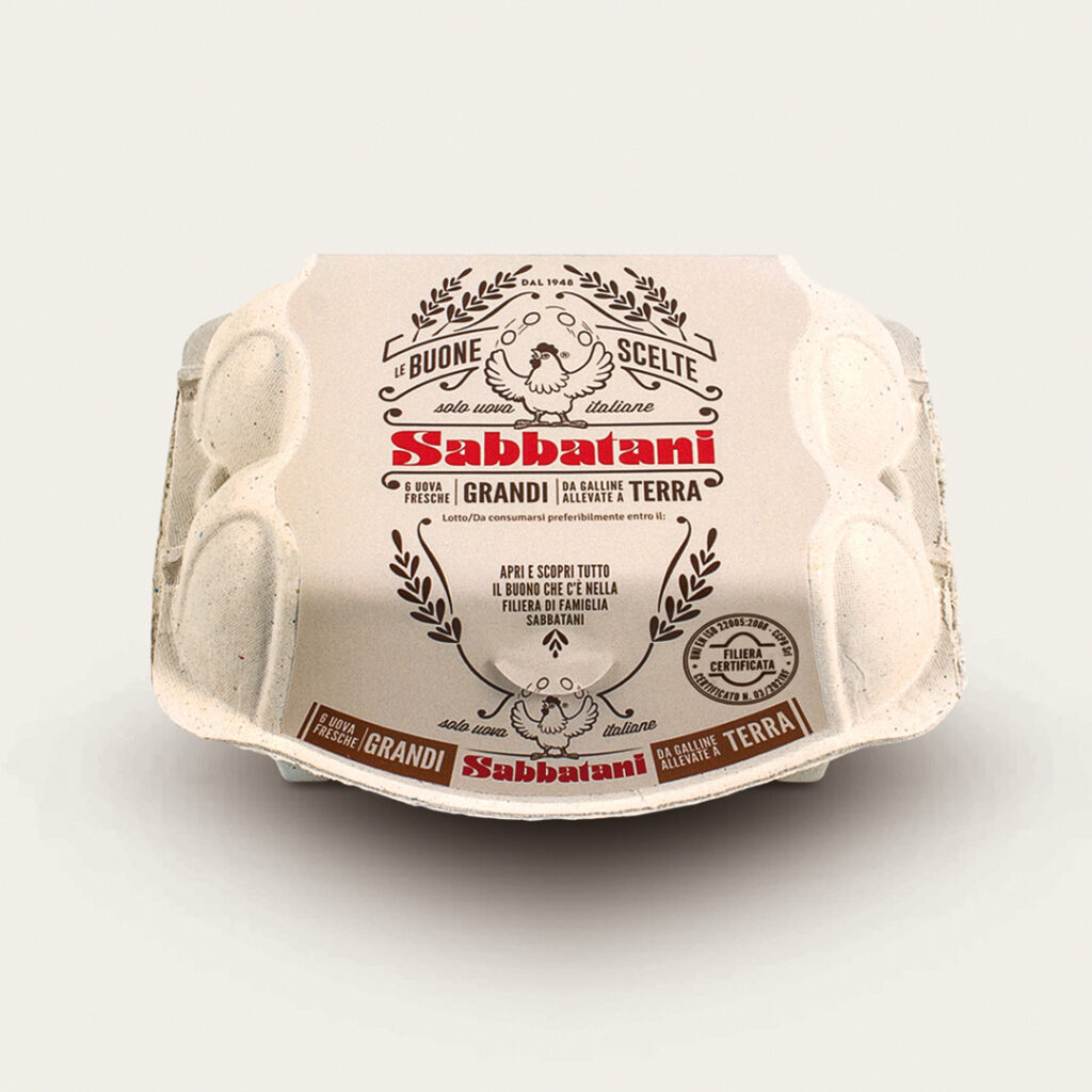 The stand experience that brings the brand to life. - Immagine 3 Six-pack of Sabbatani eggs designed by Menabò, made from recycled cardboard, featuring a vintage-style graphic and a red logo on a beige background. Labeled as fresh eggs from free-range hens.